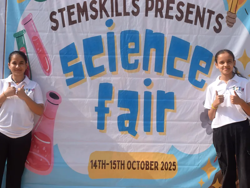 Two StemSkills students in front of the banner for the STEMskills science fair, 14 and 15 October 2025