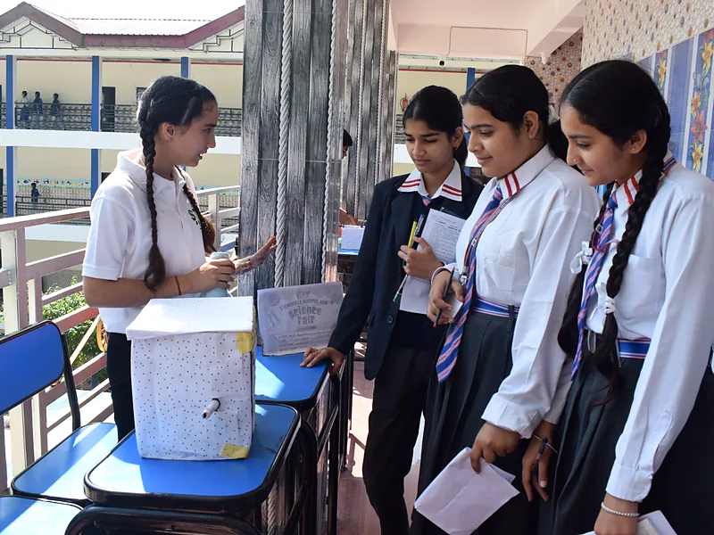 Students presenting their project at a table during the StemSkills science fair